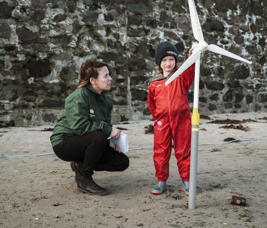 ScottishPower Employee teaches a young child about windmills with prop